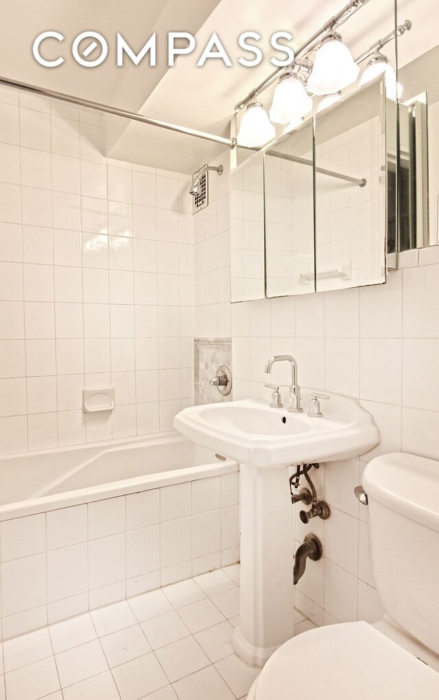 420 E 64th St Unit W4D, New York City, NY 10065 - bathroom featuring tiled shower / bath, tile walls, and tile patterned flooring
