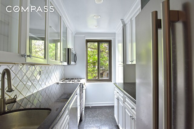 420 E 64th St Unit W4D, New York City, NY 10065 - kitchen featuring appliances with stainless steel finishes, decorative backsplash, dark stone countertops, white cabinets, and granite tiled floors