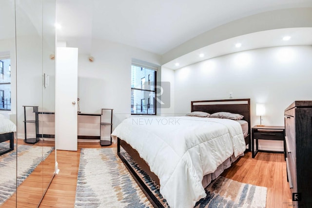 bedroom with wood finished floors, recessed lighting, and baseboards