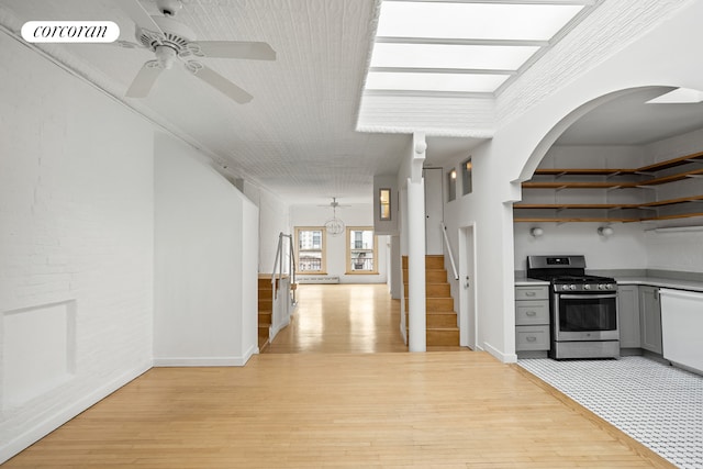 kitchen with stainless steel range with gas cooktop, gray cabinets, ceiling fan, light wood finished floors, and white dishwasher