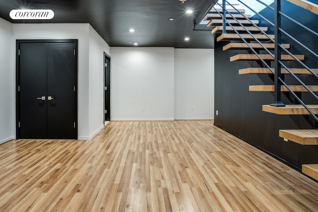 unfurnished living room with wood finished floors, baseboards, stairs, and recessed lighting