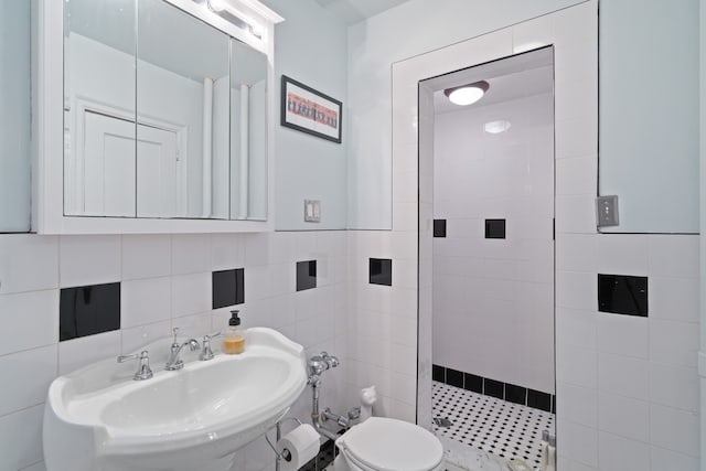 35-06 88th St Unit 5-D, New York City, NY 11414 - full bath featuring tiled shower, a sink, toilet, and tile walls