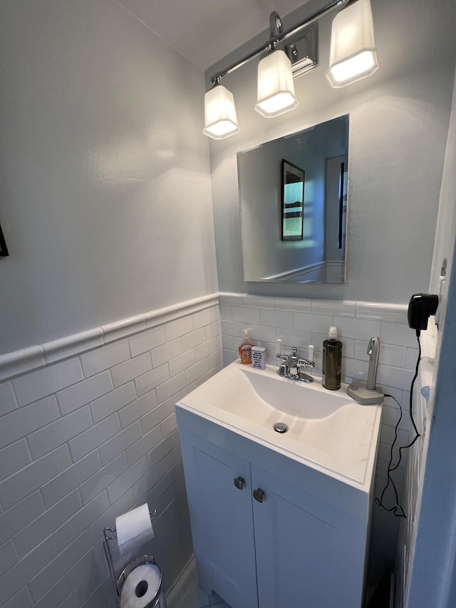 bathroom with tile walls, a wainscoted wall, and vanity