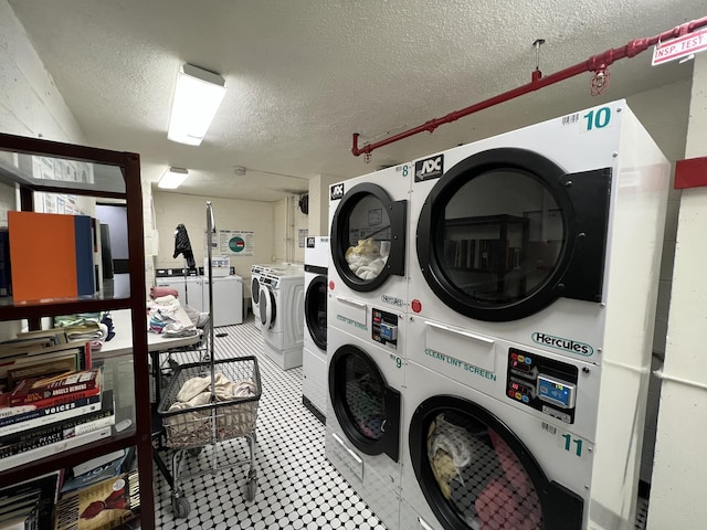 shared laundry featuring stacked washer / drying machine, a textured ceiling, and washing machine and clothes dryer