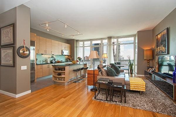kitchen featuring white microwave, baseboards, built in fridge, light wood-style floors, and open shelves