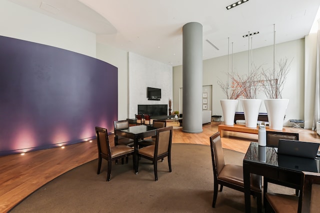dining room with wood finished floors and a towering ceiling