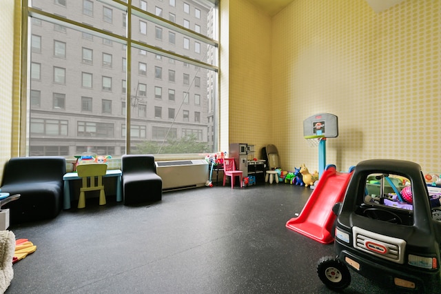 playroom with a towering ceiling and rubber floors
