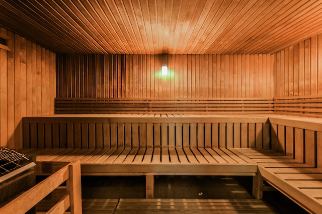 relaxing sauna / steam room featuring wooden ceiling and wooden walls