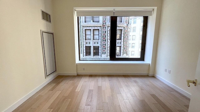 75 Wall St Unit 18Fg, New York City, NY 10005 - spare room featuring light wood-style floors and baseboards