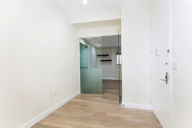 75 Wall St Unit 18Fg, New York City, NY 10005 - hall featuring light wood-style flooring, baseboards, and recessed lighting
