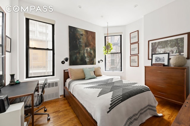 360 W 21st St Unit 2L, New York City, NY 10011 - bedroom with hardwood / wood-style flooring, radiator heating unit, and a desk