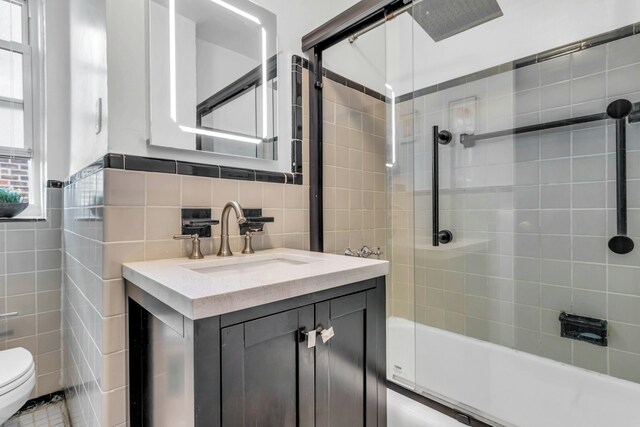 88-01 35th Ave Unit 5F, New York City, NY 11372 - full bath featuring tile walls, toilet, vanity, and tub / shower combination