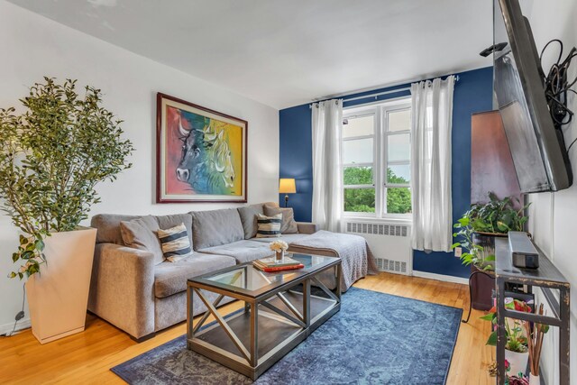 88-01 35th Ave Unit 5F, New York City, NY 11372 - living room featuring radiator heating unit, wood finished floors, and baseboards