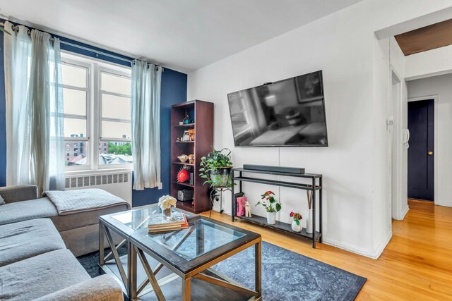 88-01 35th Ave Unit 5F, New York City, NY 11372 - living room with radiator, wood finished floors, and baseboards