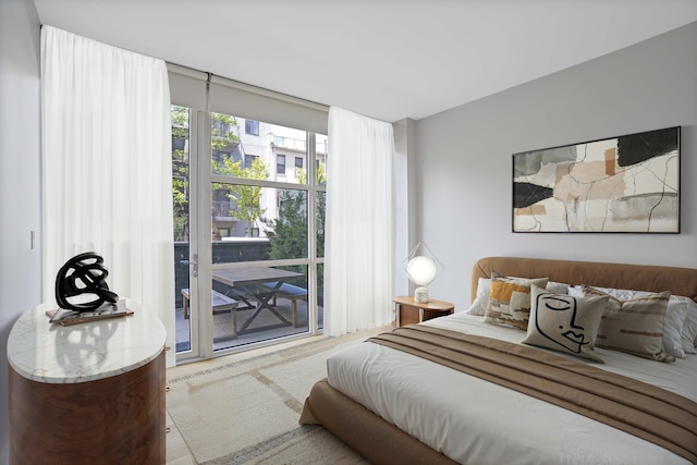 bedroom with access to outside and wood finished floors