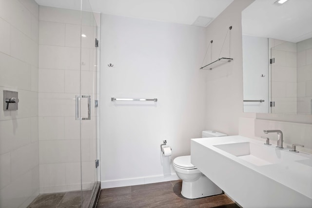 bathroom with toilet, a stall shower, baseboards, and vanity