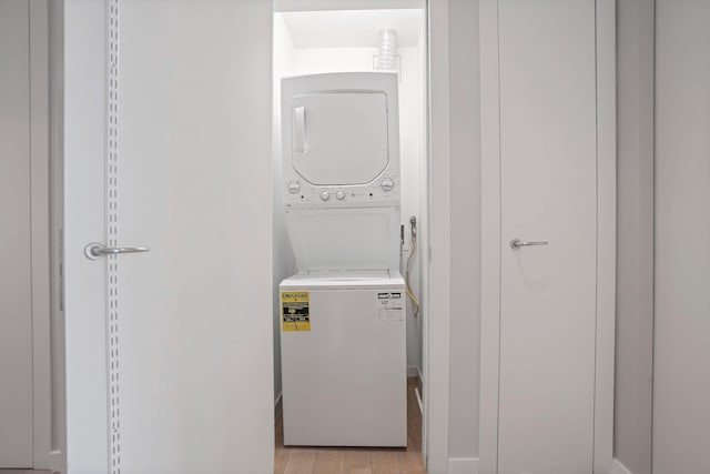 laundry area featuring estacked washer and dryer and light wood-style flooring