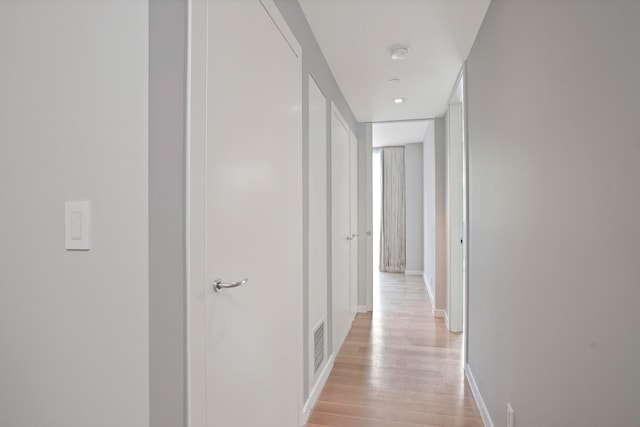 hallway featuring light wood-style floors and baseboards
