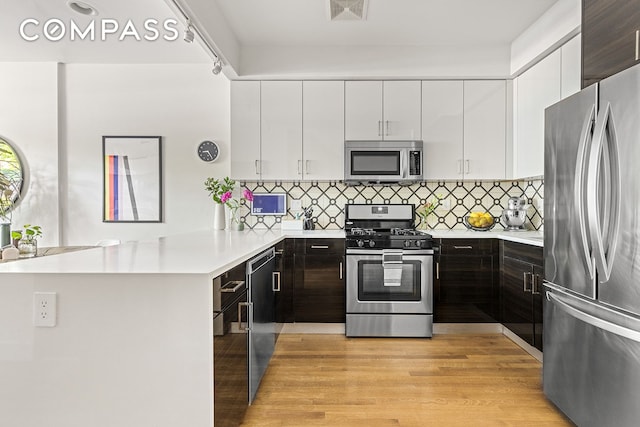495 Rutland Rd Unit 1, New York City, NY 11203 - kitchen with appliances with stainless steel finishes, light countertops, a peninsula, and white cabinetry