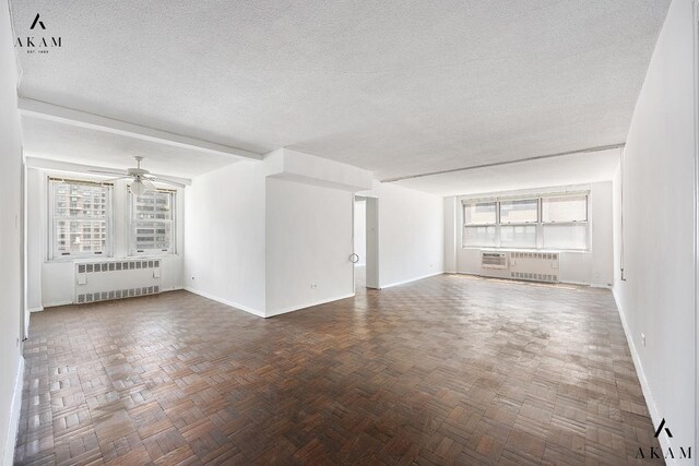 unfurnished living room with radiator, a textured ceiling, baseboards, and a ceiling fan