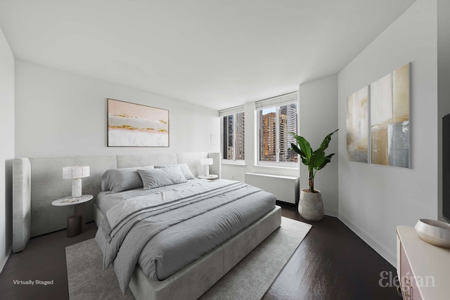 bedroom featuring wood finished floors, baseboards, and radiator