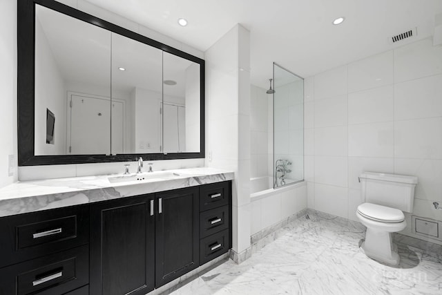 bathroom featuring a combined bath / shower with rainfall shower, toilet, vanity, tile walls, and recessed lighting