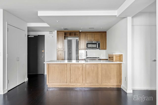kitchen with stainless steel appliances, a peninsula, light countertops, dark wood finished floors, and recessed lighting