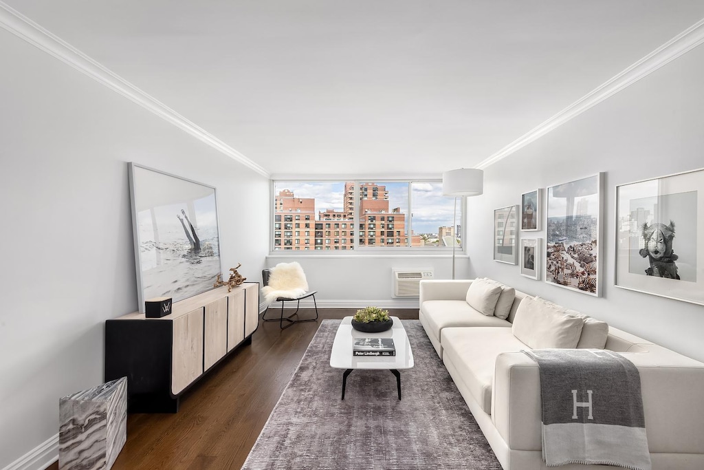 595 Main St Unit 814, New York City, NY 10044 - living room with crown molding, dark wood-type flooring, a wall mounted air conditioner, and a view of city