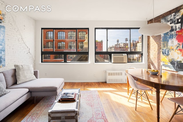 23 E 10th St Unit 815, New York City, NY 10003 - living room with hardwood / wood-style flooring, a city view, radiator heating unit, and brick wall