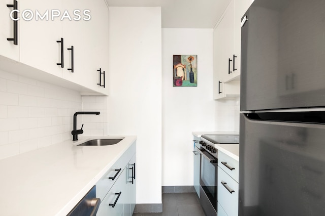 23 E 10th St Unit 815, New York City, NY 10003 - kitchen featuring stainless steel appliances, backsplash, light countertops, white cabinets, and dark tile patterned flooring