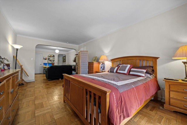 bedroom with arched walkways and crown molding