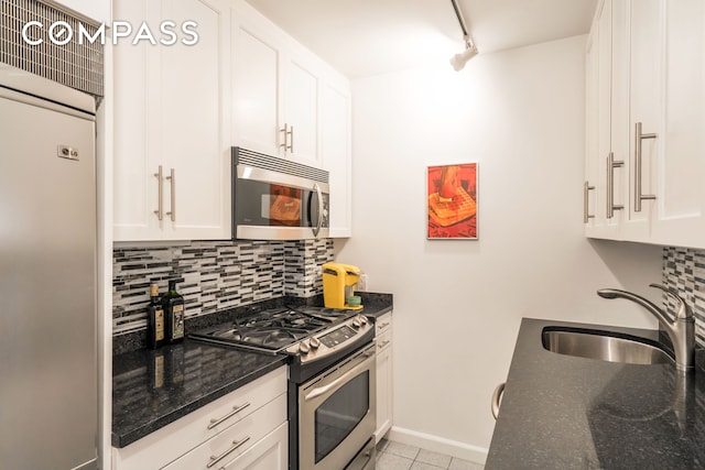 230 E 15th St Unit 8N, New York City, NY 10003 - kitchen with appliances with stainless steel finishes, tasteful backsplash, white cabinets, dark stone counters, and light tile patterned floors