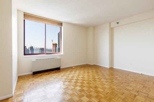 4-74 48th Ave Unit 38-H, New York City, NY 11109 - spare room with radiator heating unit and baseboards