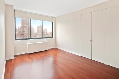 343 E 74th St Unit Ph2A, New York City, NY 10021 - unfurnished bedroom featuring wood finished floors, a closet, radiator heating unit, and a city view