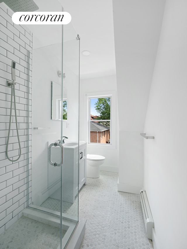 full bath with a baseboard radiator, a stall shower, toilet, baseboards, and a sink