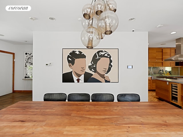 dining room featuring a chandelier, wine cooler, light wood-type flooring, and recessed lighting