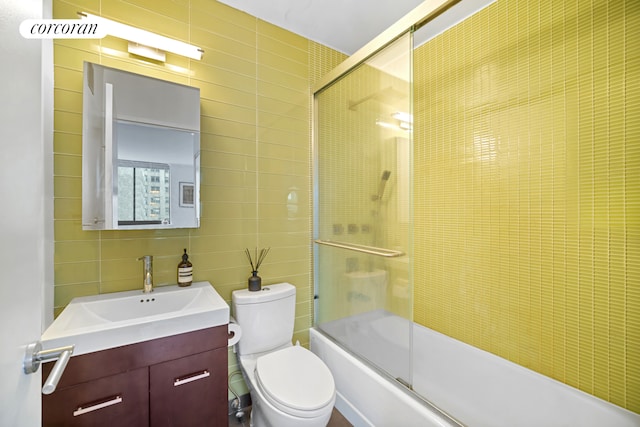 250 E 40th St Unit 17F, New York City, NY 10016 - bathroom with tile walls, vanity, and combined bath / shower with glass door