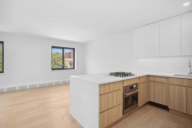 1330 5th Ave Unit 4M, New York City, NY 10026 - kitchen featuring appliances with stainless steel finishes, modern cabinets, light wood finished floors, and plenty of natural light