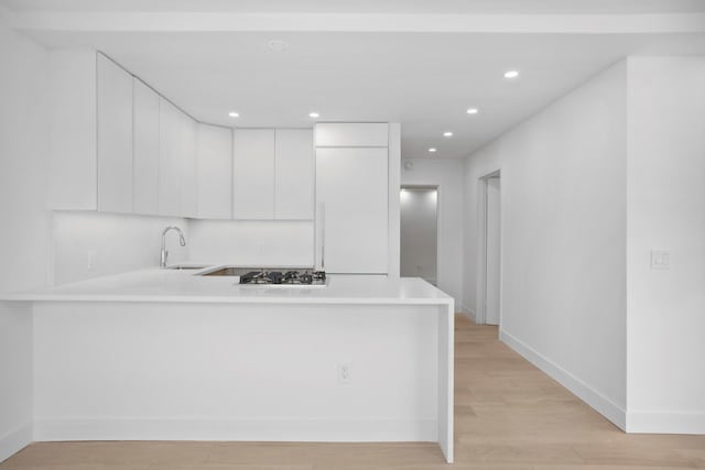 1330 5th Ave Unit 4M, New York City, NY 10026 - kitchen with light countertops, a peninsula, white cabinetry, recessed lighting, and light wood finished floors
