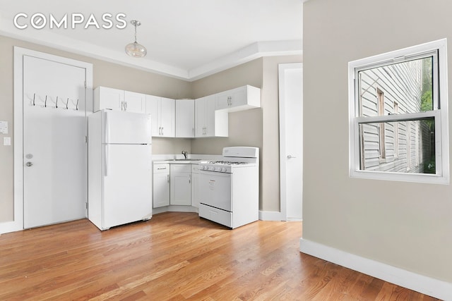 kitchen with white appliances, a sink, white cabinets, light countertops, and light wood-type flooring