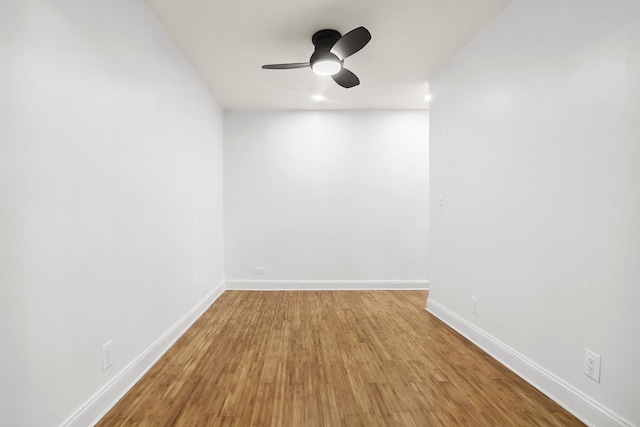 spare room with wood finished floors, baseboards, and a ceiling fan