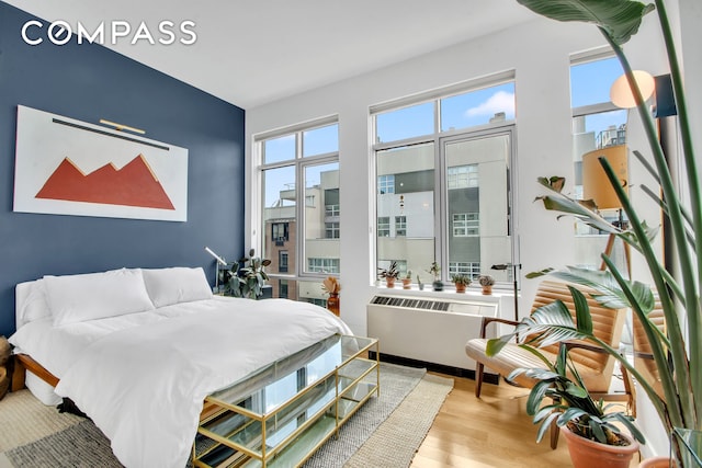 bedroom featuring wood finished floors and radiator heating unit