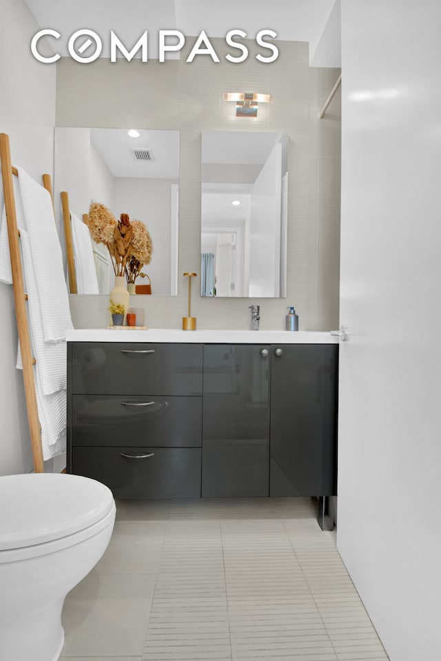 bathroom with vanity, tile patterned flooring, and toilet