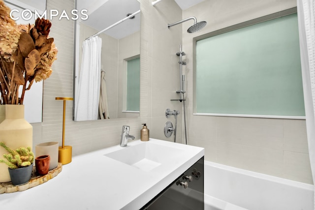 bathroom featuring decorative backsplash, curtained shower, a bathtub, vanity, and tile walls