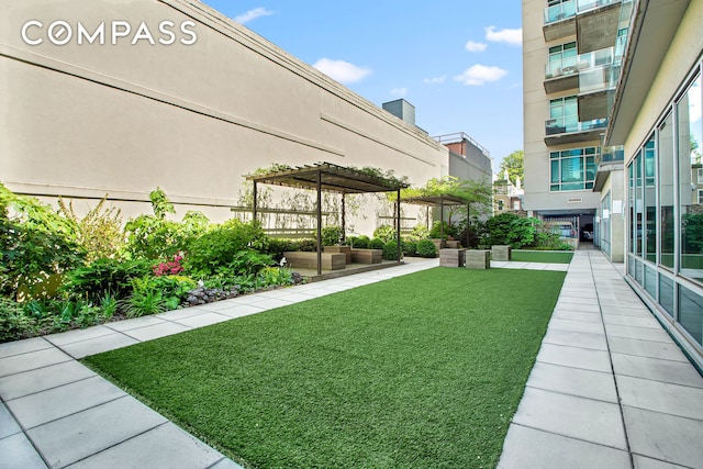 view of property's community featuring a yard and a pergola