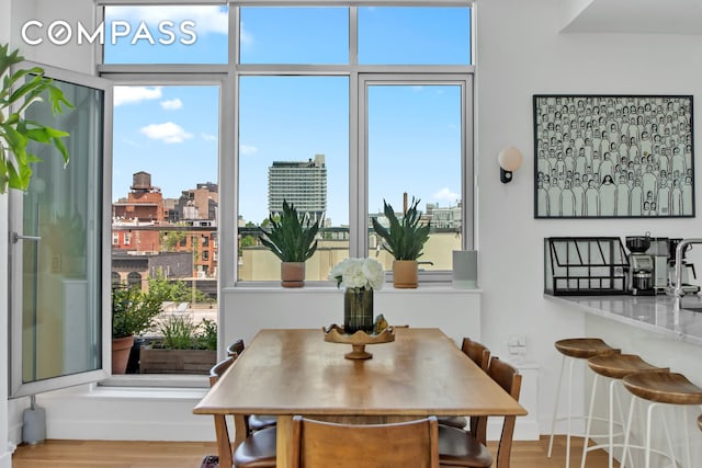 dining area with wood finished floors, plenty of natural light, and a view of city