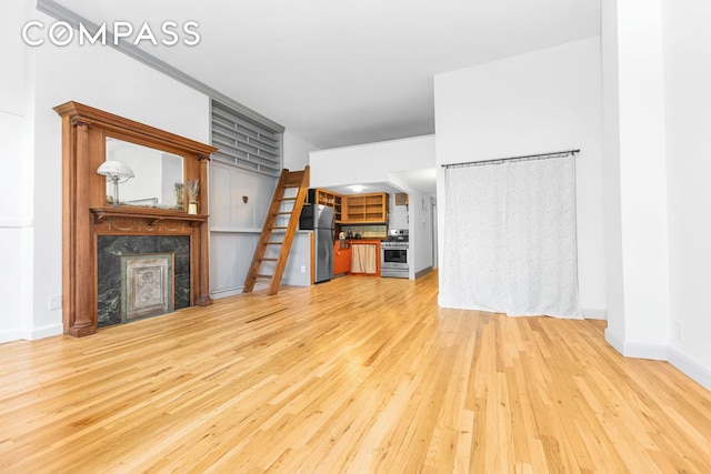 unfurnished living room featuring light wood-style floors, a fireplace, and baseboards