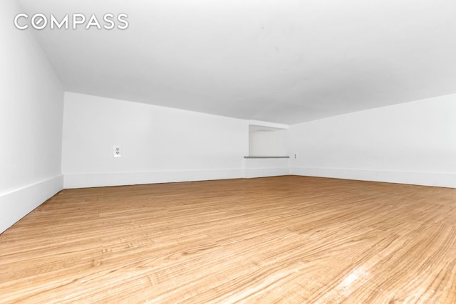 bonus room with light wood-style floors and baseboards