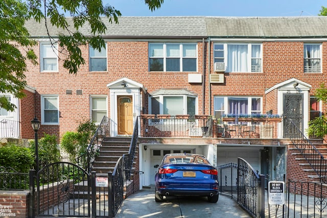 26-08 24th Ave, New York City, NY 11102 - view of property with stairway, a gate, an attached garage, driveway, and a shingled roof