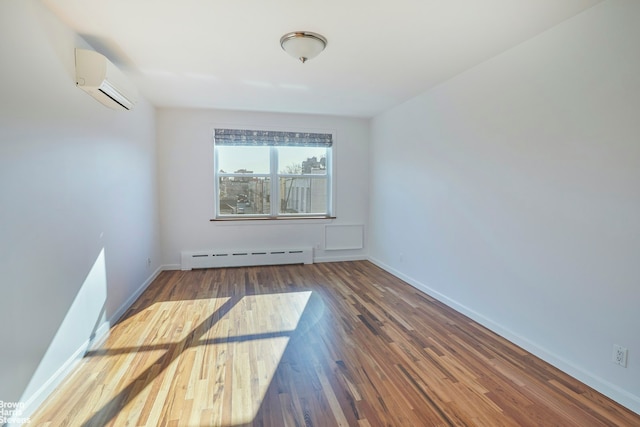 26-08 24th Ave, New York City, NY 11102 - empty room featuring baseboard heating, a wall mounted air conditioner, wood finished floors, and baseboards